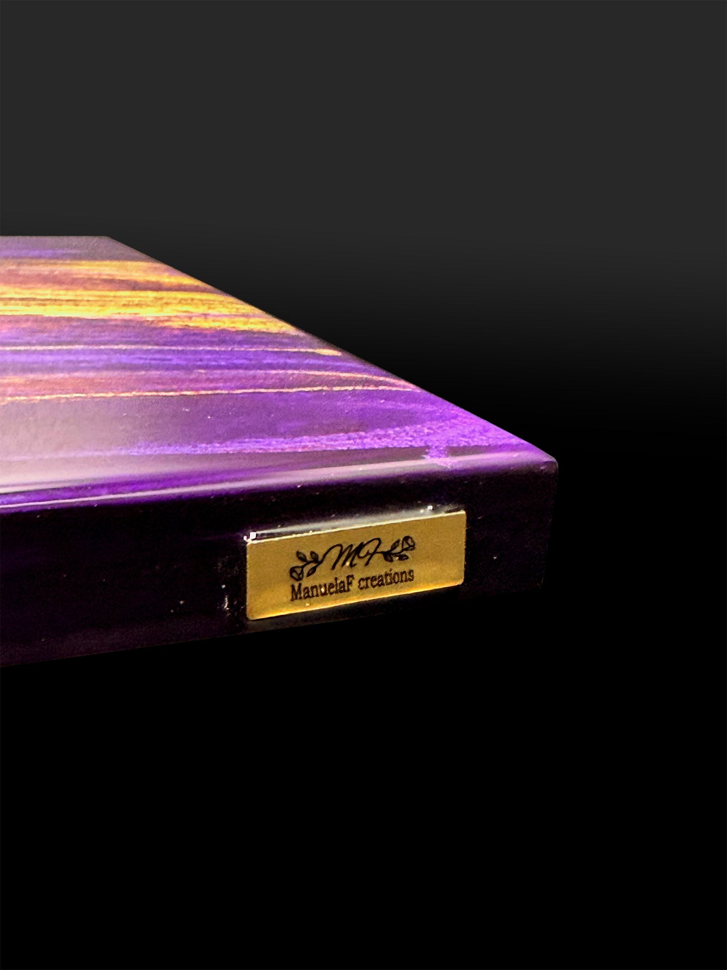 Gold artist badge on the edge of the artpiece
