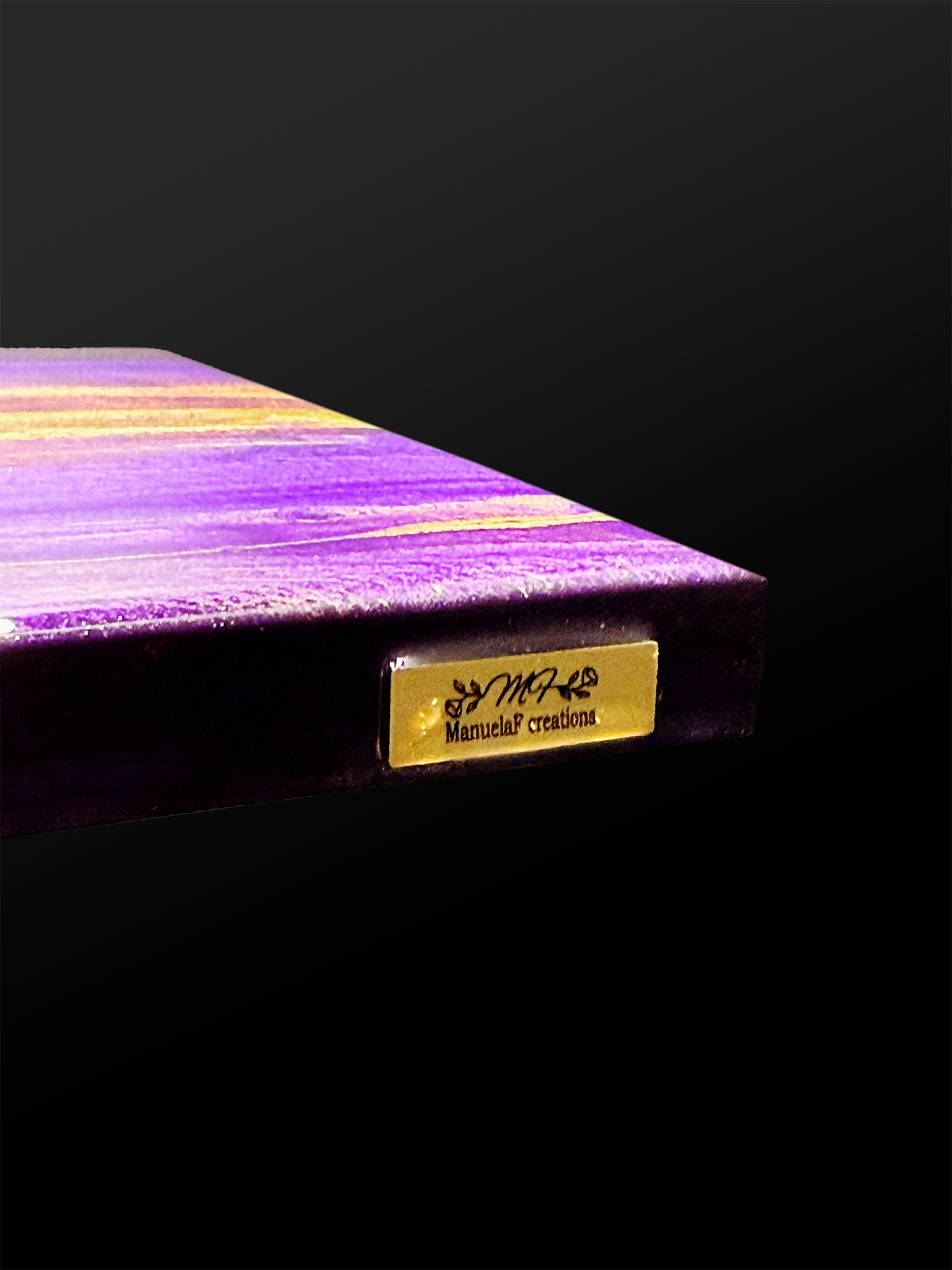 Gold artist badge on the edge of the artpiece