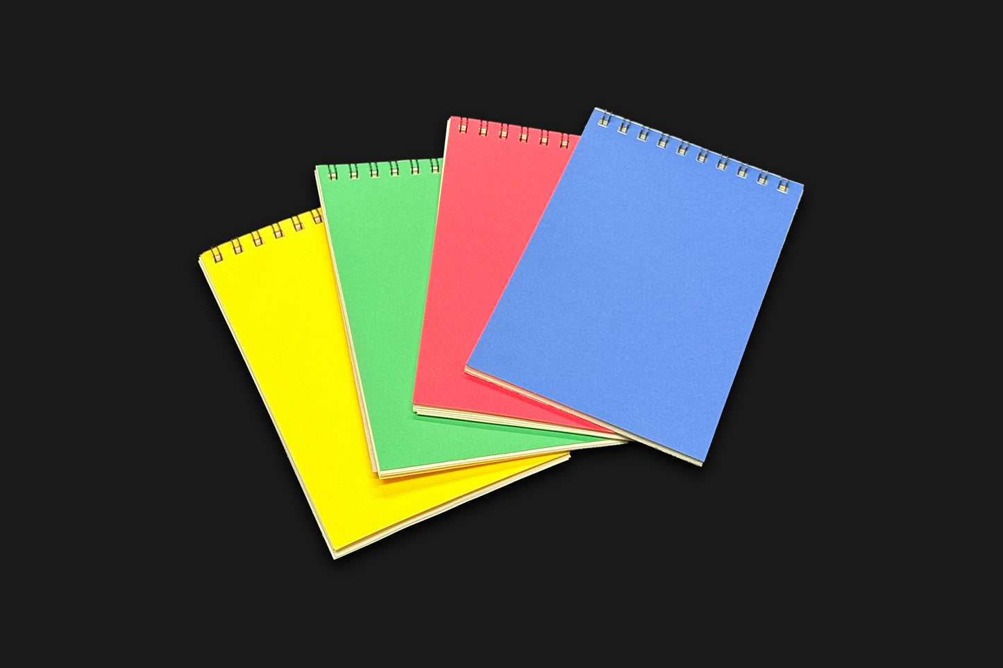 A set of 4 notebooks, yellow, green, red, blue